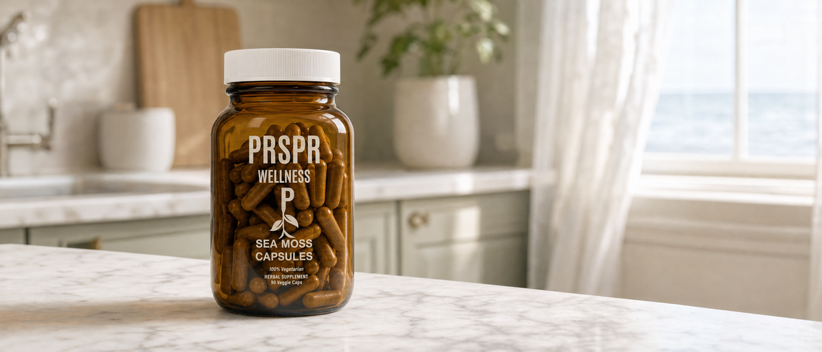 PRSPR Wellness Sea Moss Capsules amber jar on a marble kitchen counter with a bright coastal window behind it