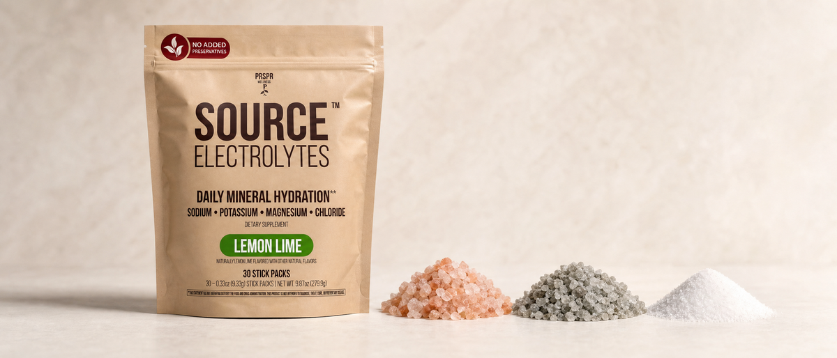 PRSPR Wellness Source Electrolytes pouch beside piles of Himalayan pink salt, grey sea salt, and white table salt