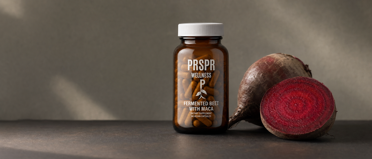 PRSPR Wellness Fermented Beet Root and Maca bottle on a dark surface beside fresh beetroot