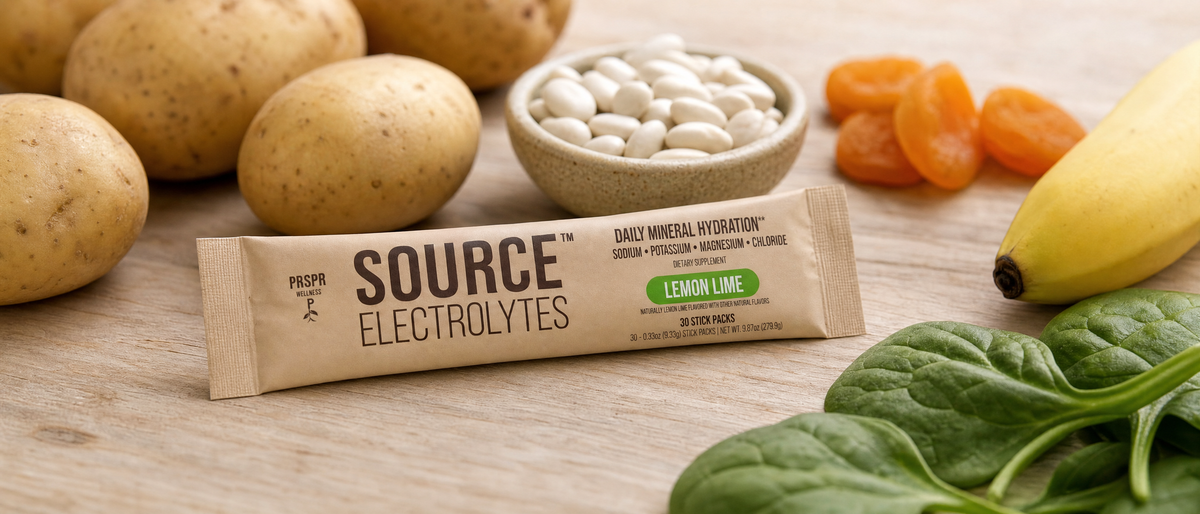 PRSPR Wellness Source Electrolytes stick pack beside potatoes, white beans, dried apricots, spinach and a banana