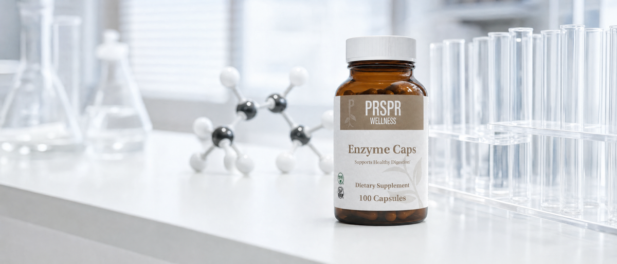 Enzyme Caps bottle on a white laboratory bench beside a ball-and-stick molecular model and glass test tubes