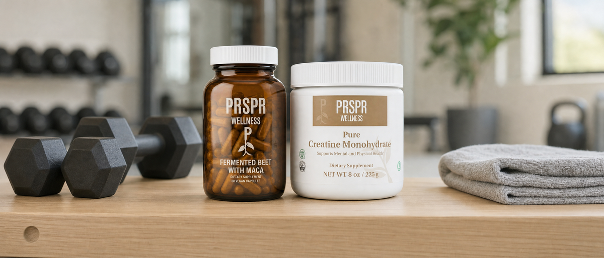 PRSPR Natures BBL bundle: Fermented Beet with Maca and Pure Creatine Monohydrate on a gym bench beside hex dumbbells and a folded towel