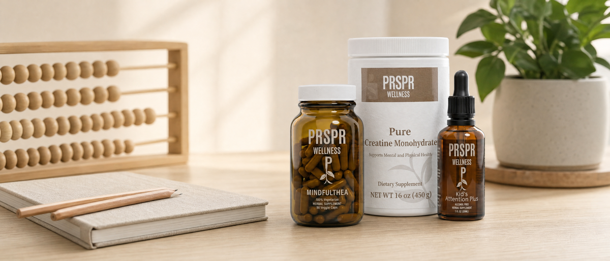 PRSPR Wellness MindfulThea, Pure Creatine Monohydrate and Attention Plus on an oak office desk beside a wooden abacus, a linen notebook and pencils.