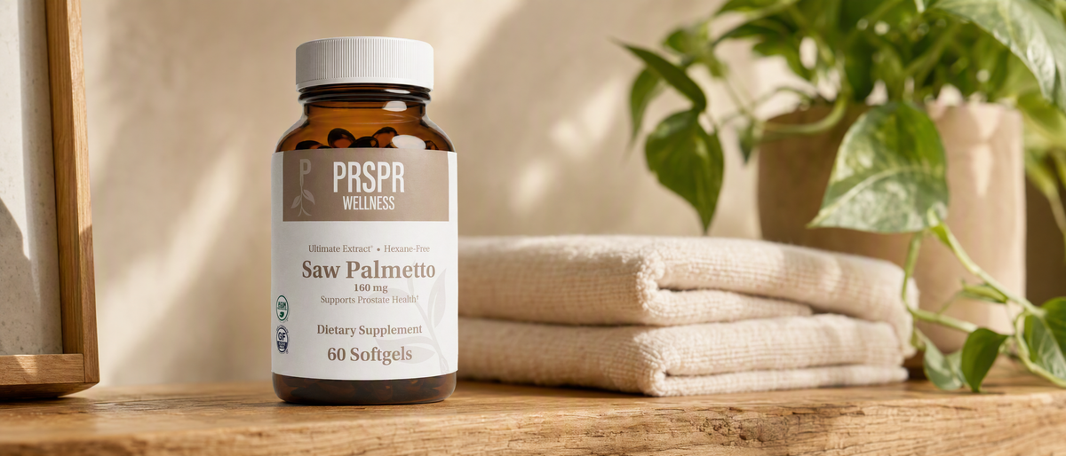 PRSPR Wellness Saw Palmetto bottle of 60 softgels on a wooden shelf beside folded towels and a green plant