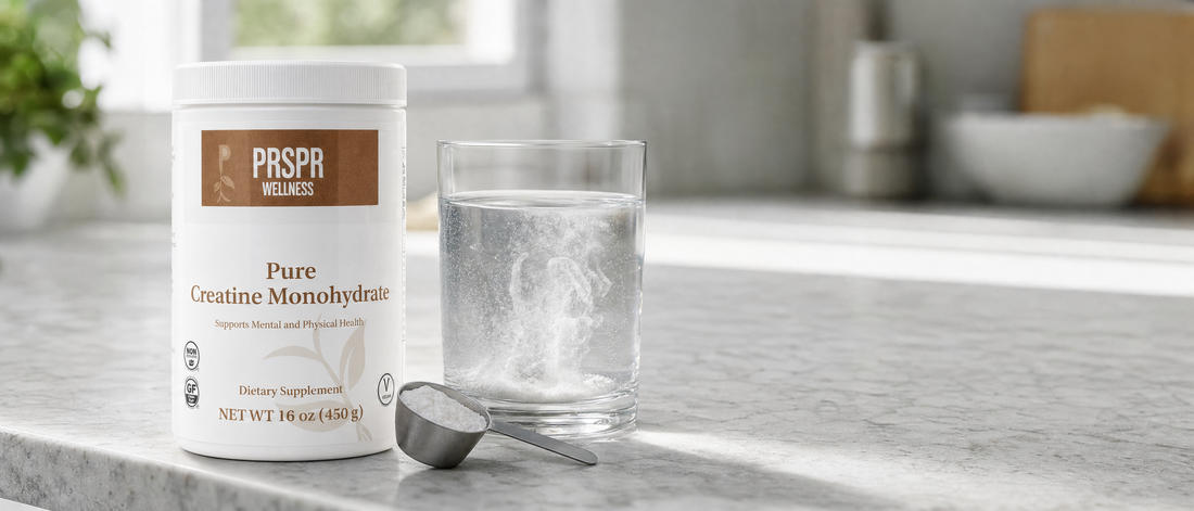 PRSPR Pure Creatine Monohydrate 16 oz tub beside a glass of water with creatine powder dispersing and a steel scoop