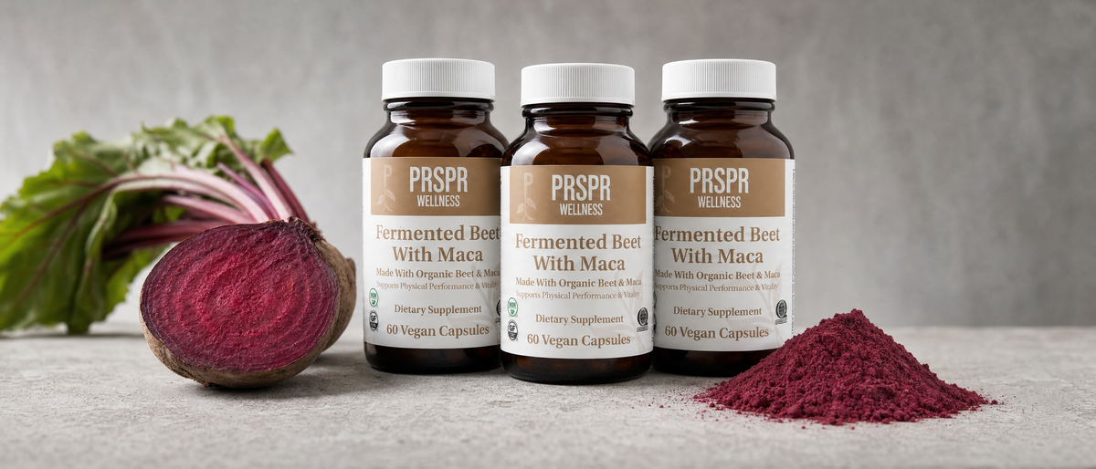 Three PRSPR Fermented Beet With Maca capsule bottles beside a halved raw beetroot and a heap of beet root powder