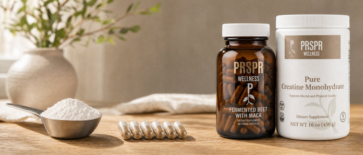 PRSPR Wellness Nature's BBL Deluxe set on warm oak beside a steel scoop of powder and a row of clear capsules