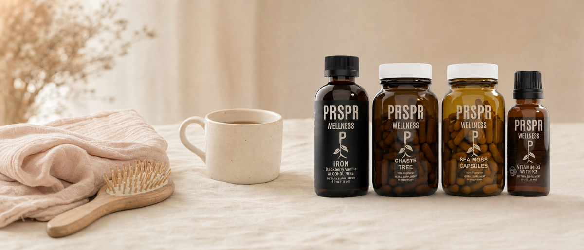 PRSPR Wellness Pre and Post Natal Bundle on cream linen beside a folded muslin cloth, wooden hairbrush and mug of tea