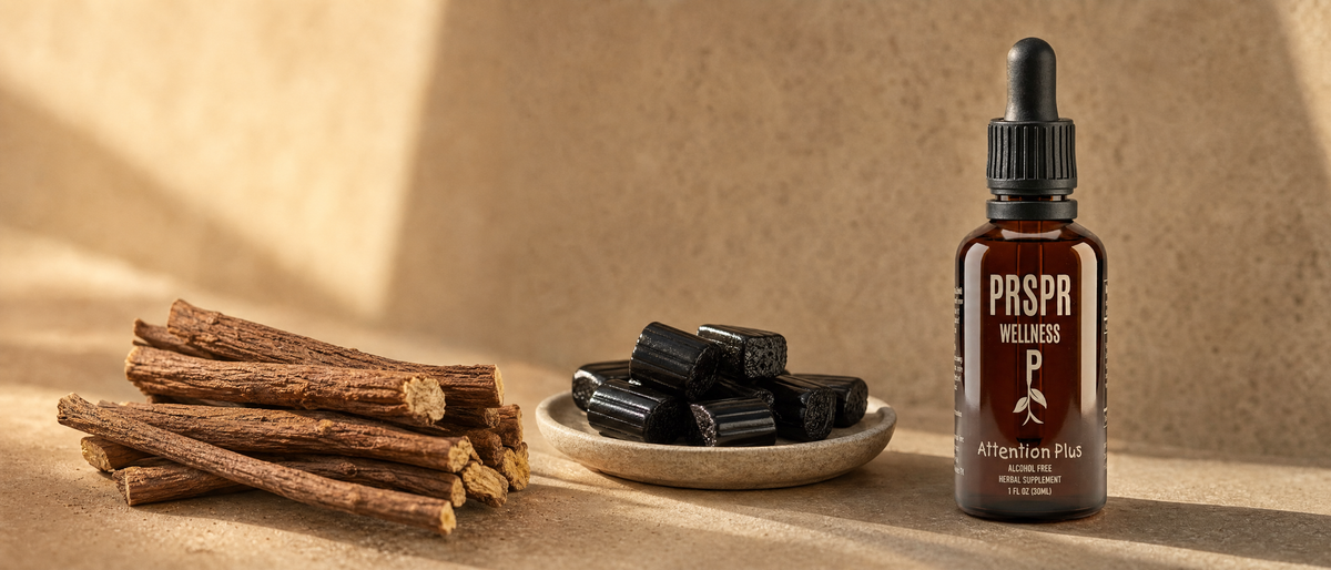 PRSPR Wellness Attention Plus bottle on warm sand beside a bundle of dried licorice root sticks and a dish of black licorice candy