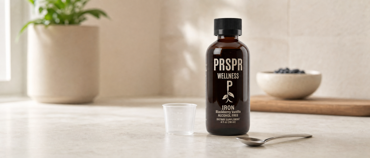 PRSPR Wellness Liquid Iron bottle beside a measuring spoon on a kitchen counter