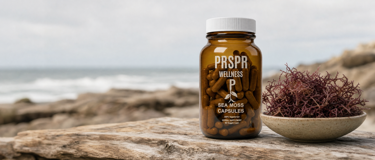 PRSPR Wellness Sea Moss Capsules bottle beside a bowl of dried red Irish moss seaweed on driftwood