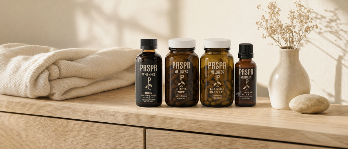 PRSPR Wellness Pre & Post Natal Bundle bottles on a sunlit oak dresser beside a folded cream knit blanket and a vase of dried flowers